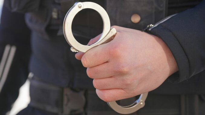 Polizei Handschellen - Symbolbild Polizisten nehmen nach einem Messerangriff in Kiel einen Verdächtigen fest. Der Mann sitzt nun in U-Haft. (Archivbild)