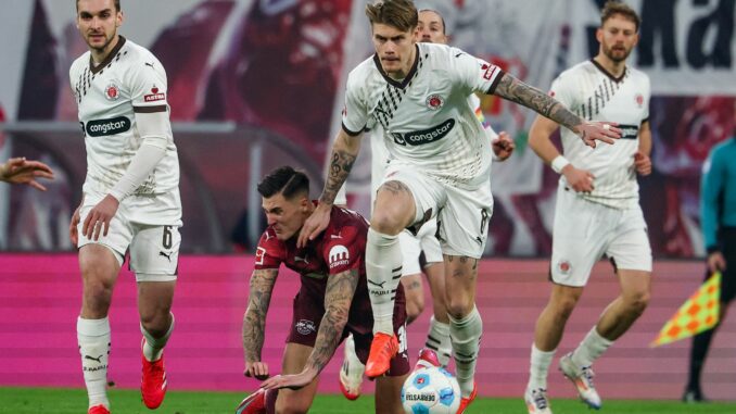 RB Leipzig - FC St. Pauli St. Paulis Abwehrchef Eric Smith setzt sich gegen Leipzigs Benjamin Sesko durch.