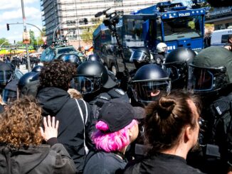 Polizisten drängen Teilnehmer der Gegendemonstration von der Straße.
