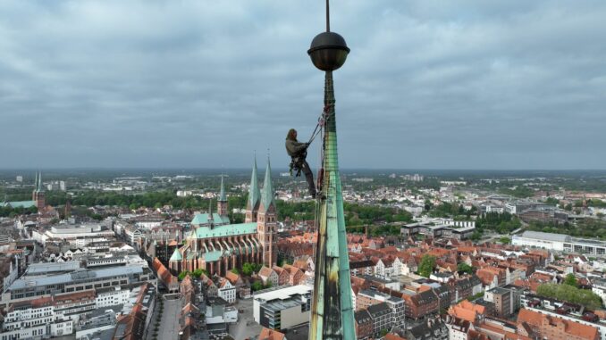 Industriekletterer an Lübecker Jakobikirche Ein Industriekletterer sichert Teile der kaputten Kupferverkleidung am Turm der Lübecker Jakobikirche.