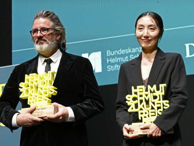 Olafur Eliasson und Hwanhee Hwang stehen mit dem Helmut-Schmidt-Zukunftspreis auf der Bühne im Hamburger Thalia Theater.
