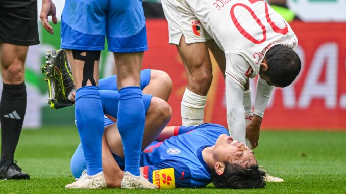 FC Augsburg - Holstein Kiel Das Aus für Shuto Machino: Der Kieler Angreifer liegt in Augsburg verletzt am Boden.