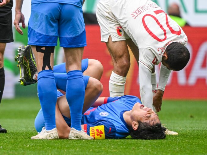 Das Aus für Shuto Machino: Der Kieler Angreifer liegt in Augsburg verletzt am Boden.