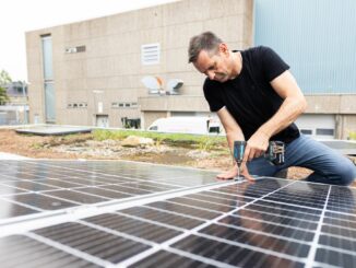 Olaf Lies, damals noch als Wirtschaftsminister, montiert ein Solarmodul auf ein Dach. (Archivbild)