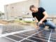 Olaf Lies, damals noch als Wirtschaftsminister, montiert ein Solarmodul auf ein Dach. (Archivbild)