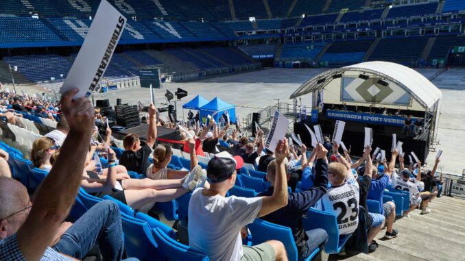 Mitgliederversammlung des Hamburger SV HSV-Fans halten Stimmzettel bei der Mitgliederversammlung des Clubs hoch.