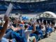 HSV-Fans halten Stimmzettel bei der Mitgliederversammlung des Clubs hoch.