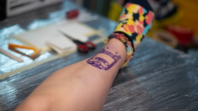 Tattoo Eine Frau lässt sich eine Tätowierung auf ihr Bein stechen. (Symbolfoto)