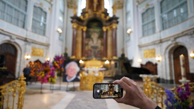 Trauerfeier für Moderator von Tiedemann Ein Besucher macht zu Beginn der Trauerfeier ein Foto mit einem Smartphone.