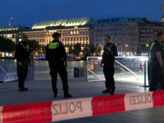 Polizeibeamte stehen am Abend im Bereich des U-Bahnhofs nahe der Binnenalster.
