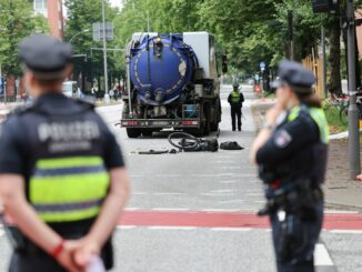 Polizeibeamte sichern und untersuchen die Unfallstelle nach einem tödlichen Fahrradunfall.
