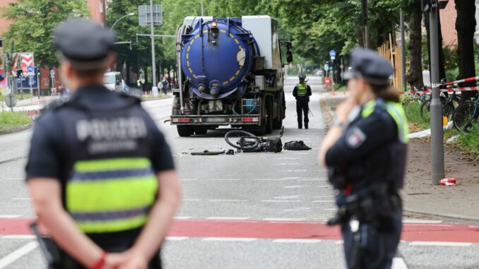 Tödlicher Unfall in Hamburg Polizeibeamte sichern und untersuchen die Unfallstelle nach einem tödlichen Fahrradunfall.
